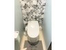 大字桜ケ丘２（聖愛中高前駅） 3200万円 トイレの様子（2023年5月撮影） ベビーブルー色の壁紙と黒と白の大きな花柄模様の壁紙でおしゃれなトイレです。階段下のスペースを有効に使ったトイレで、天棚もあります。