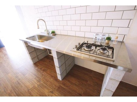 旭コーポC棟 オーダーメイドのステンレスキッチン。機能性、インテリア性もあるタイル張り。足元は武骨なコンクリートブロック。 室内（2024年1月）撮影