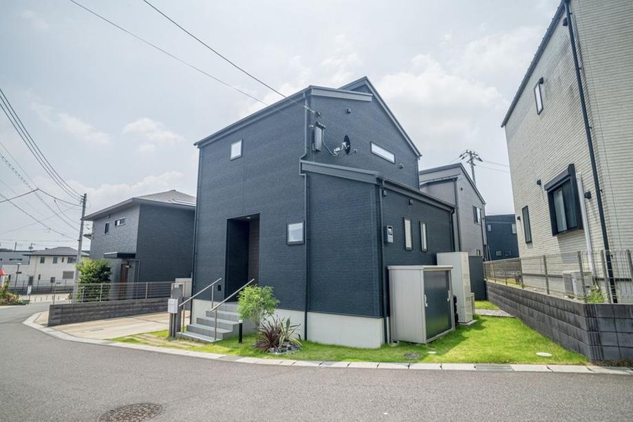 落ち着いた色合いの外観と整備された前庭が特徴の戸建住宅です。