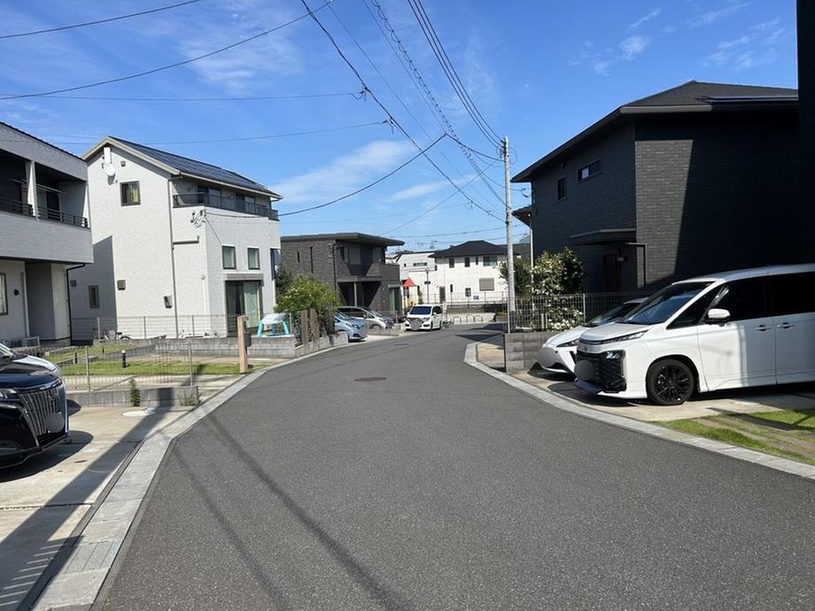 前面道路を含む外観。幅員のある道路に面し、周辺は戸建住宅が並ぶ落ち着いた街並みです。