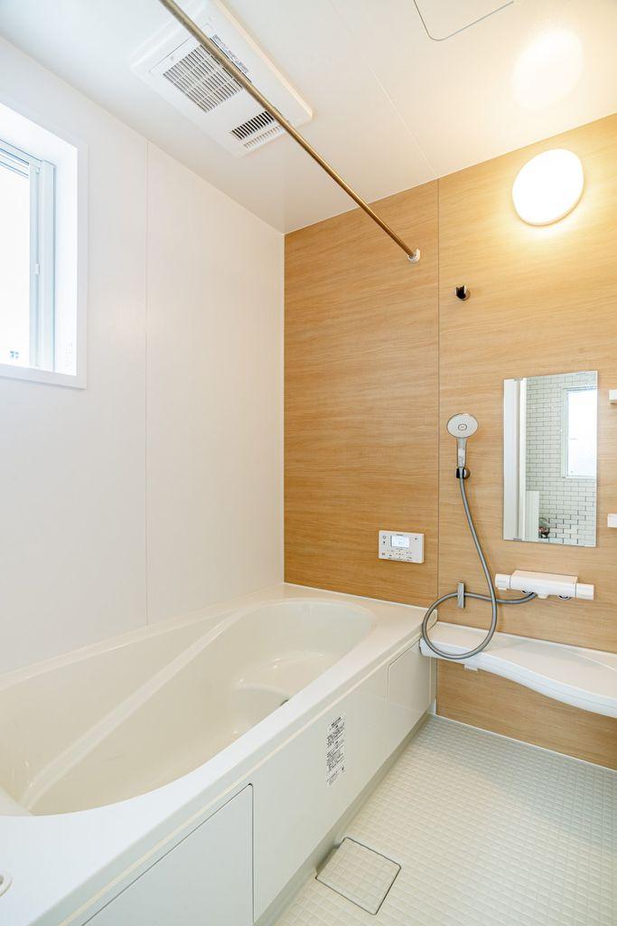 木目調パネルが温かみを感じさせる浴室。窓付きで換気も良好です。