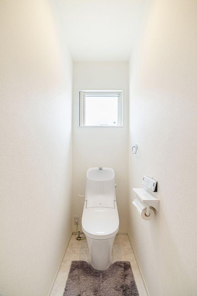 小窓付きの1階トイレ。自然光が入り、明るく清潔感のある空間です。