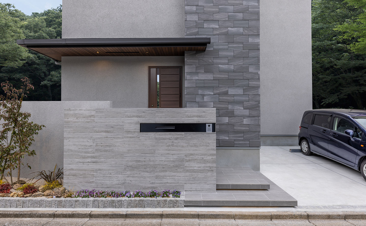 三菱地所ホーム タイルやウォルナットなど、多彩な素材が溶け合う上質な佇まい。映像を投影できる吹抜けで暮らしを愉しむの建築実例画像2