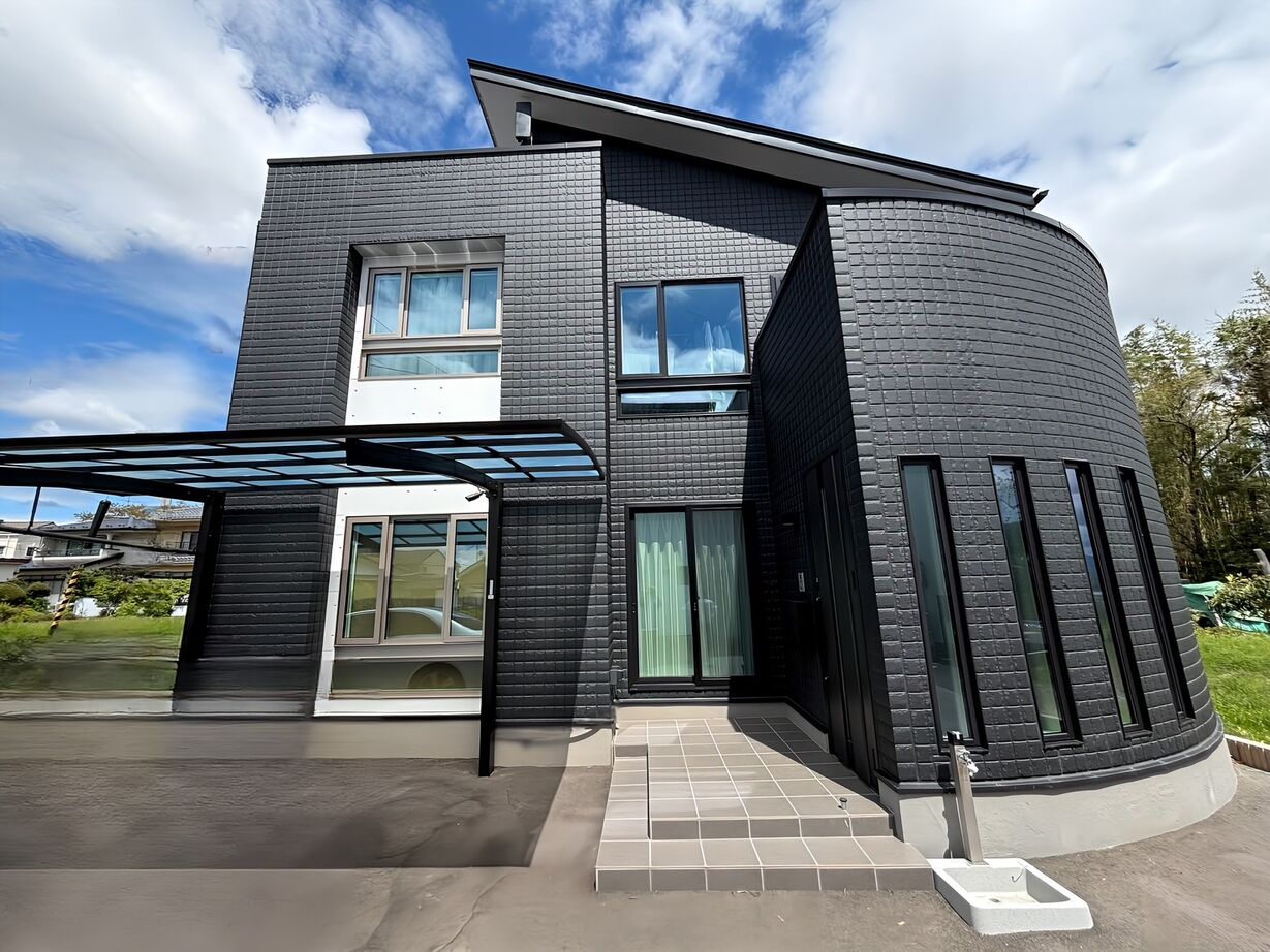 ユニバーサルホーム 重厚感と曲線の美しさが際立つブラックカラーの外観が特長の家の建築実例画像