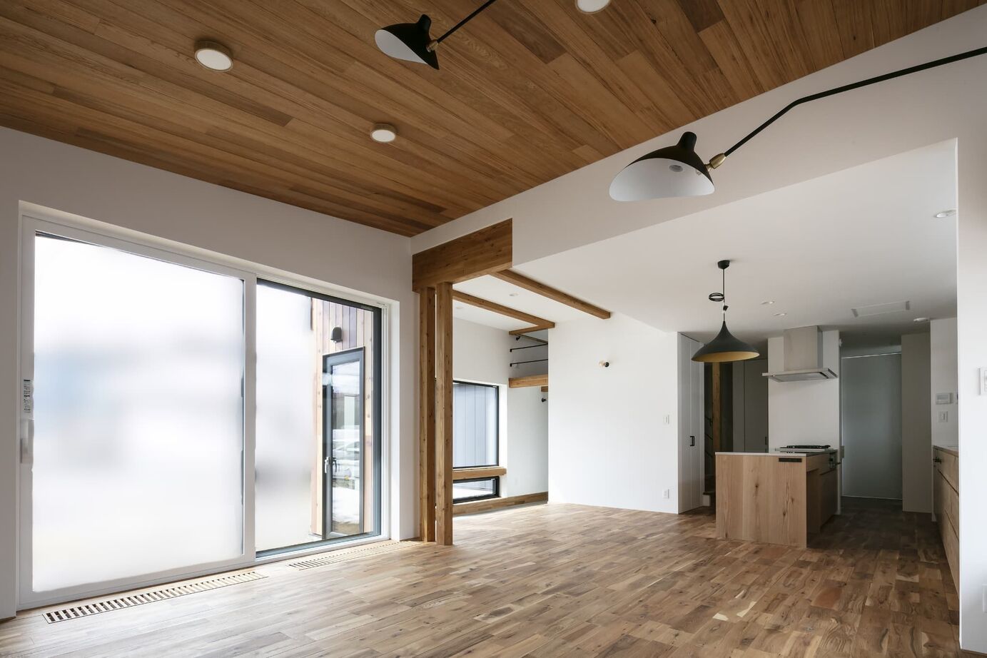 STV興発 【札幌/3LDK+フリールーム/造作キッチン/インナーガレージ】大きな窓から庭の植栽を眺められるリビングの建築実例画像2