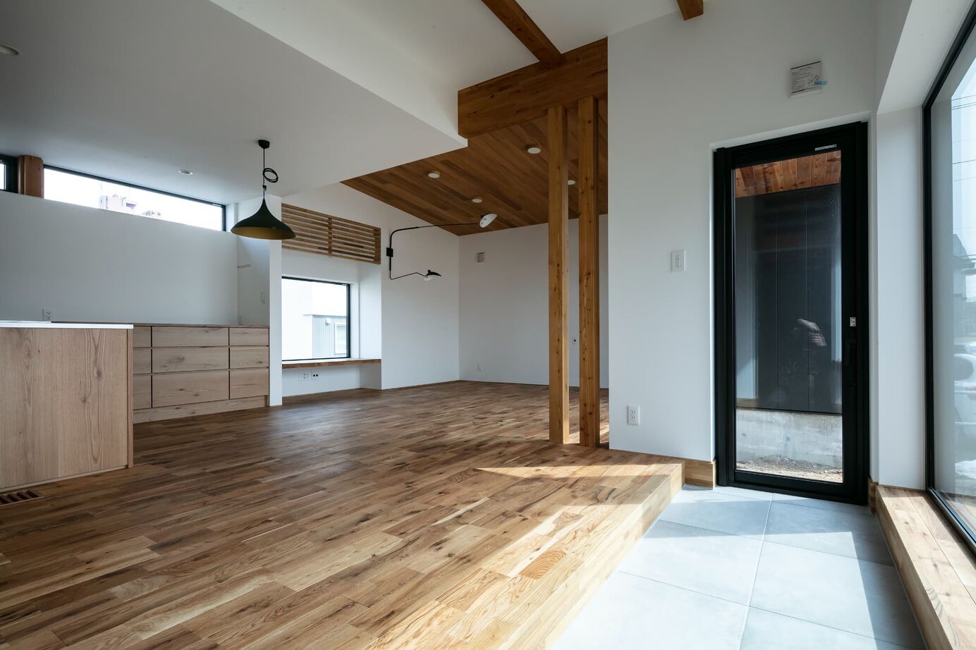 STV興発 【札幌/3LDK+フリールーム/造作キッチン/インナーガレージ】大きな窓から庭の植栽を眺められるリビングの建築実例画像3