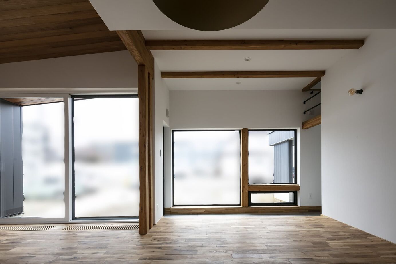 STV興発 【札幌/3LDK+フリールーム/造作キッチン/インナーガレージ】大きな窓から庭の植栽を眺められるリビングの建築実例画像4