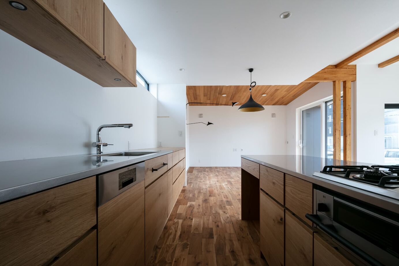 STV興発 【札幌/3LDK+フリールーム/造作キッチン/インナーガレージ】大きな窓から庭の植栽を眺められるリビングの建築実例画像5