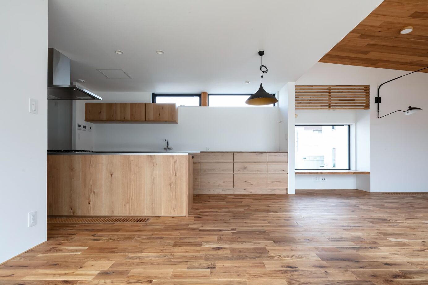 STV興発 【札幌/3LDK+フリールーム/造作キッチン/インナーガレージ】大きな窓から庭の植栽を眺められるリビングの建築実例画像6