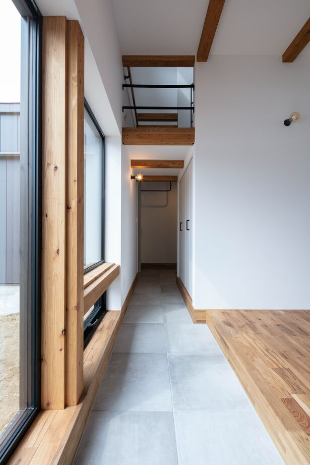 STV興発 【札幌/3LDK+フリールーム/造作キッチン/インナーガレージ】大きな窓から庭の植栽を眺められるリビングの建築実例画像9