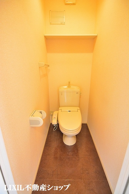 トイレ　上部に収納棚のある温水洗浄便座付のトイレです。