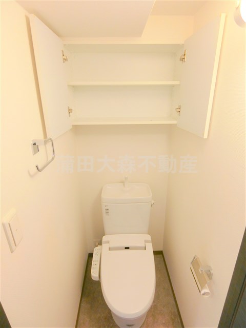 トイレ　吊戸棚と温水洗浄便座付きのトイレ