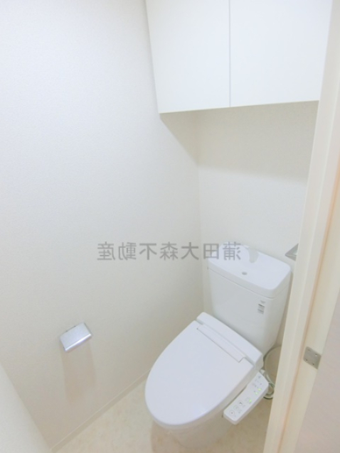 トイレ　吊戸棚と温水洗浄便座付きのトイレ