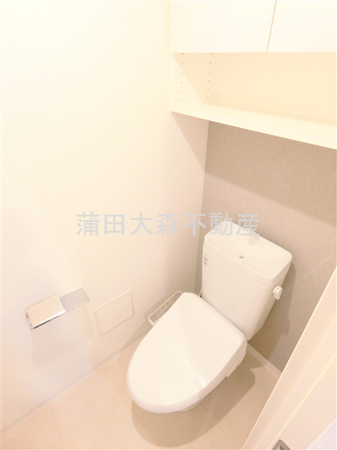 トイレ　棚と温水洗浄暖房便座付きのトイレ