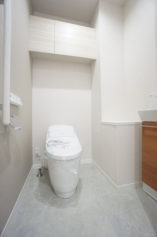 トイレ　タンクレスのスタイリッシュなトイレ。室内に手洗いシンク付き。