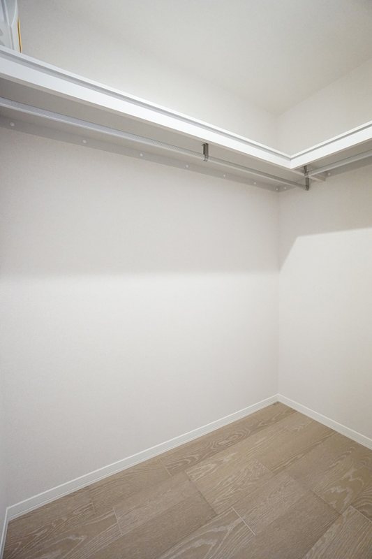 収納　洋室7.6帖　2面にハンガーパイプが備えられたWIC。