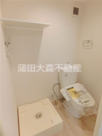 トイレ　棚付きの洗濯機置き場　温水洗浄便座付きのトイレ