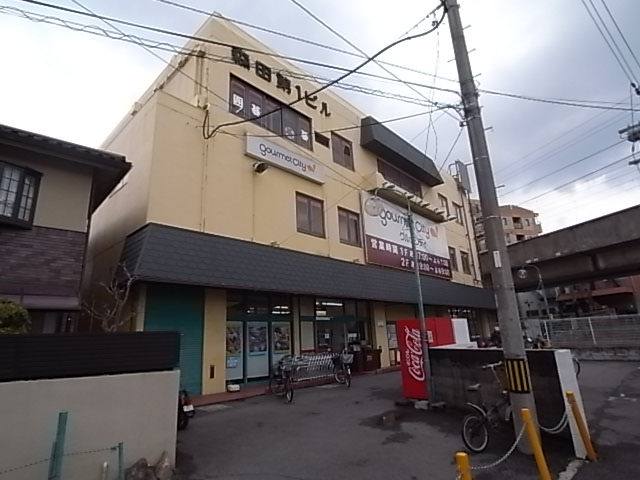 スーパー　グルメシティ忍ケ丘店（スーパー）まで295m