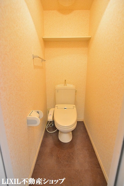 トイレ　上部に収納棚のある温水洗浄便座付のトイレです。