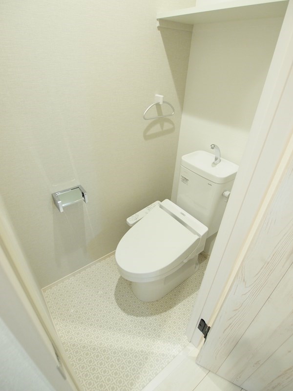 トイレ　温水洗浄便座。上部に棚あり。