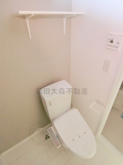 トイレ　棚と温水洗浄便座付きのトイレ