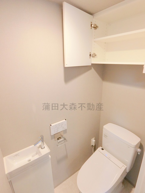 トイレ　吊り戸棚収納温水洗浄便座付きのトイレ