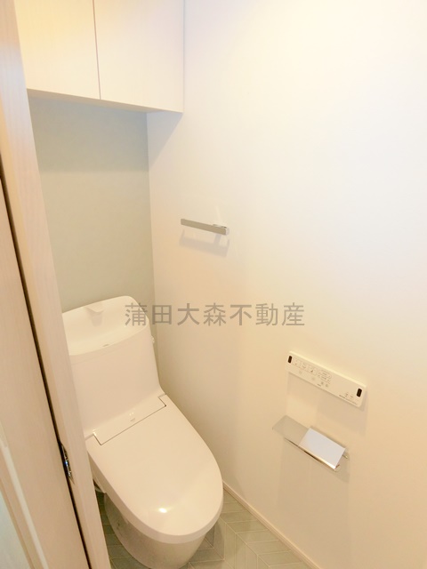 トイレ　棚収納と温水洗浄便座付きのトイレ