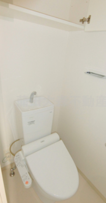 トイレ　上部棚収納に温水洗浄便座付きのトイレ