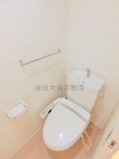 トイレ　棚と温水洗浄便座付きのトイレ