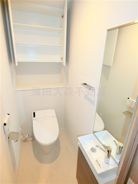 トイレ　棚収納に温水暖房便座タンクレスのスタイリッシュなトイレ　手洗