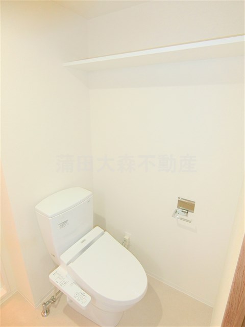トイレ　棚と温水洗浄便座付きのトイレ