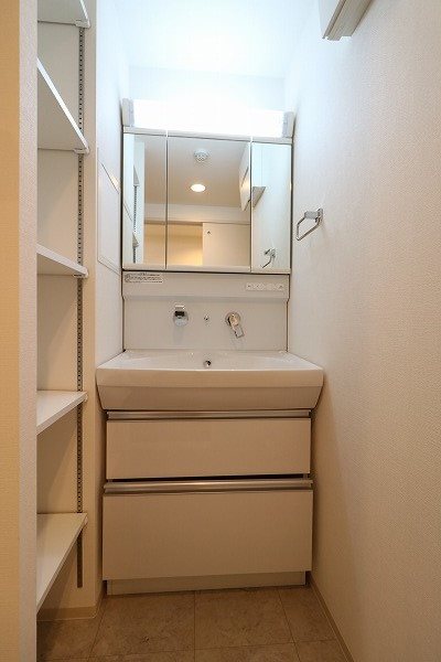 洗面設備　可動式棚付きの洗面所はタオルなど適材適所にしまえて便利です。