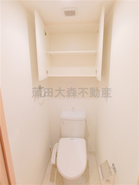 トイレ　棚収納と温水暖房便座付のトイレ