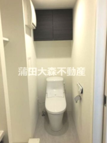 トイレ　吊戸棚収納と温水洗浄便座付きのトイレ