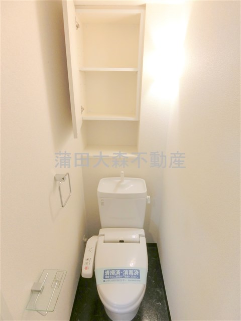 トイレ　吊戸棚と温水洗浄便座付きのトイレ
