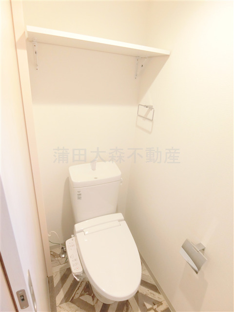 トイレ　棚と温水洗浄便座付きのトイレ