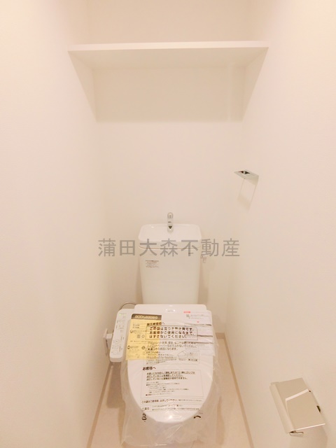 トイレ　棚と温水洗浄便座付きのトイレ