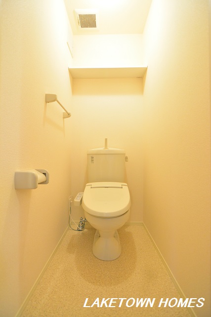 トイレ　上部に収納棚がある温水洗浄暖房便座付のトイレです。