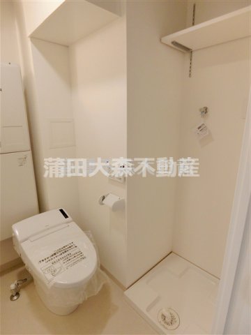 トイレ　棚付きの洗濯機置き場　温水洗浄便座付きのタンクレストイレ
