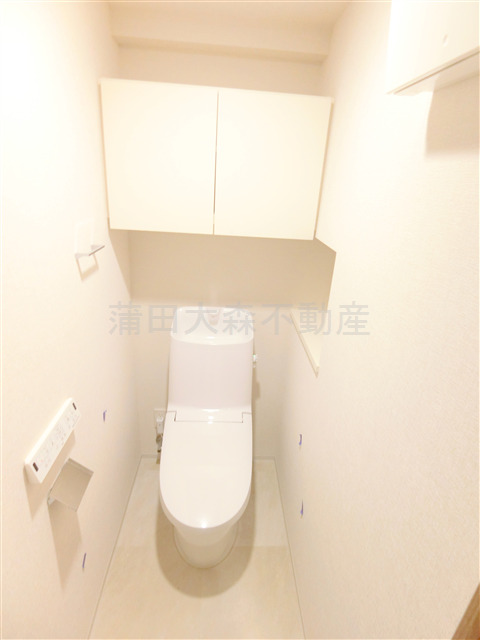トイレ　吊戸棚収納と温水洗浄便座付きのトイレ