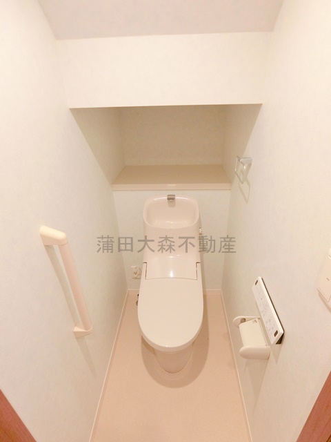 トイレ　棚と温水洗浄便座付きのトイレ