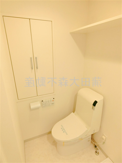 トイレ　棚と温水洗浄便座付きのトイレ