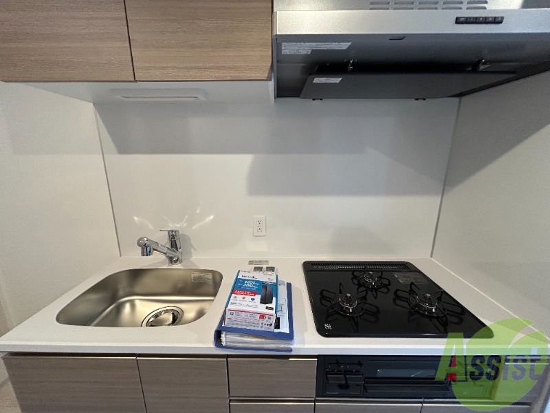 キッチン　３口のガスコンロとグリルが設置済みのシステムキッチンです。