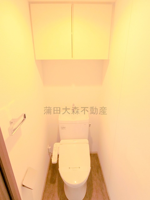 トイレ　吊り戸棚と温水洗浄便座付きのトイレ