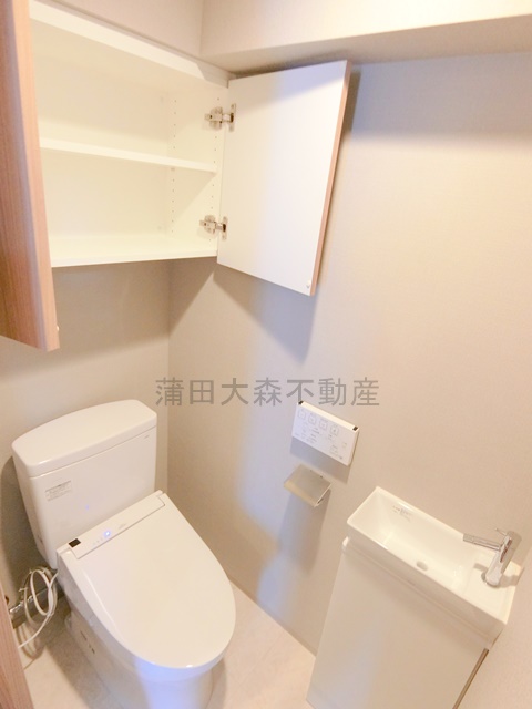 トイレ　吊り戸棚収納温水洗浄便座付きのトイレ