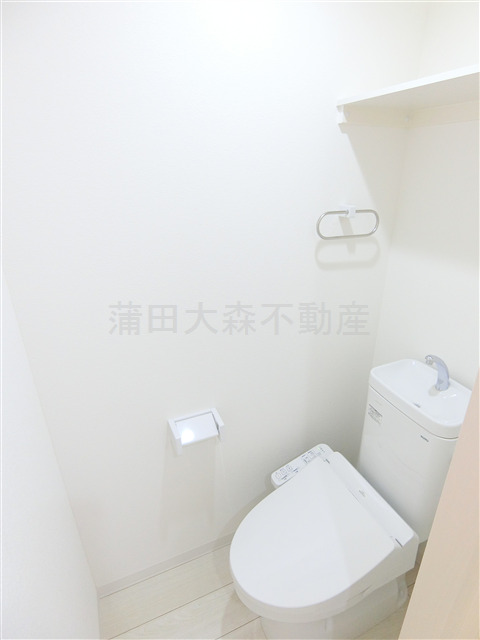 トイレ　棚と温水洗浄便座付きのトイレ