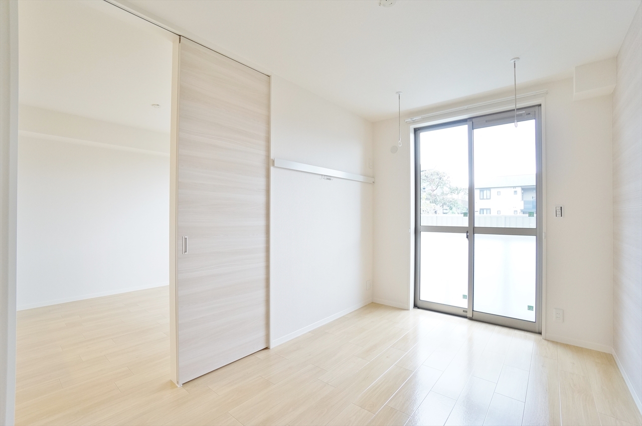 居室・リビング　6帖居室、アクセントクロス、電動シャッター