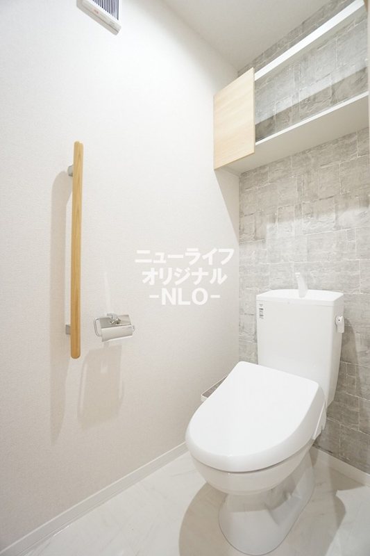 トイレ　快適な温水洗浄便座付き。上部には吊戸棚も付いています。