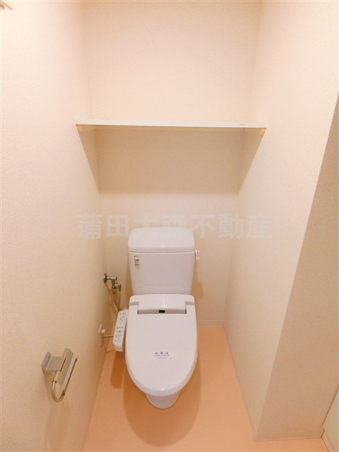 トイレ　棚と温水洗浄便座付きのトイレ
