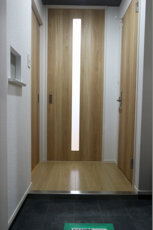 玄関　白タイルを基調とした作りになっております。